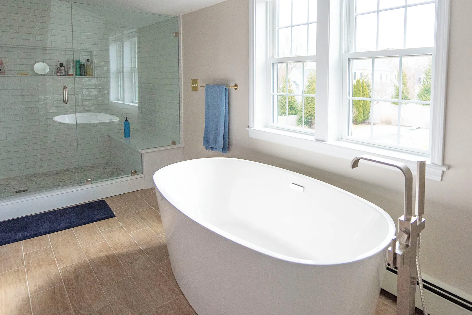 This custom home renovation features a luxury bath with soaking tub, heated floors, walking glass shower, and beautiful custom tiling.