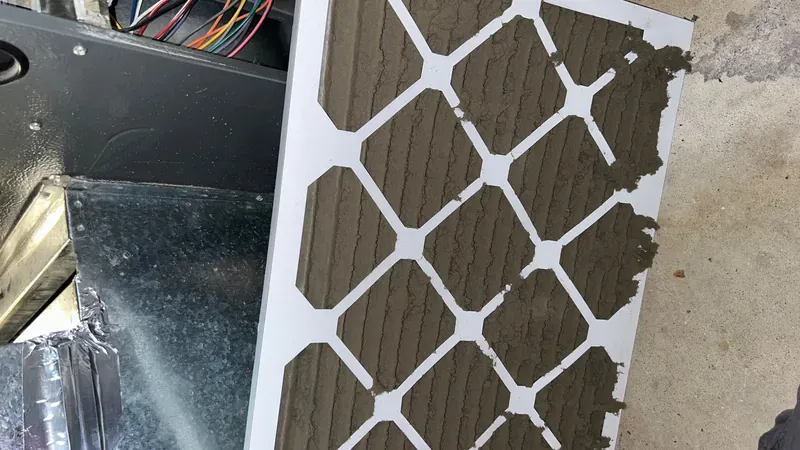 HVAC furnace air filter completely clogged with dust before replacement