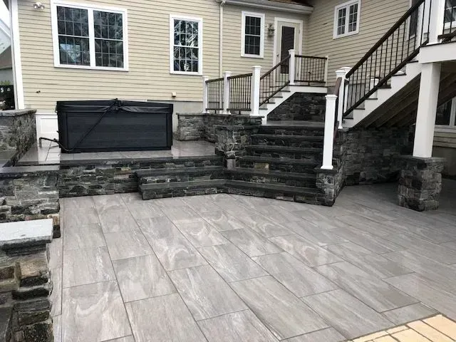 A patio with stairs leading up to a house.