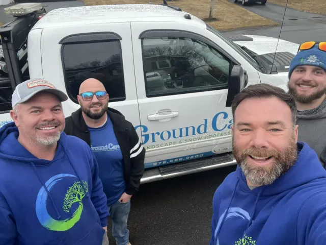 Groundcare landscaping team taking picture in front of white truck