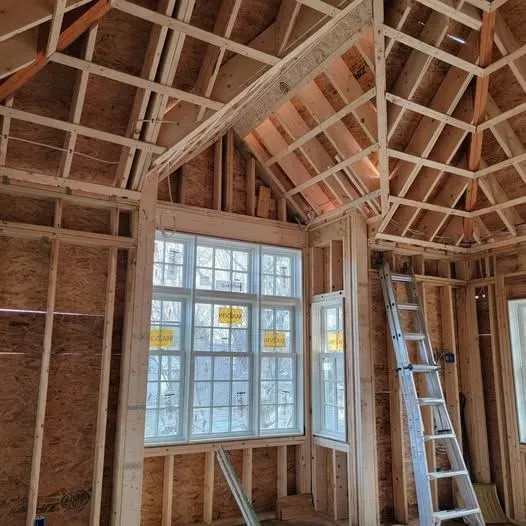 the inside of a house under construction with a ladder and new windows