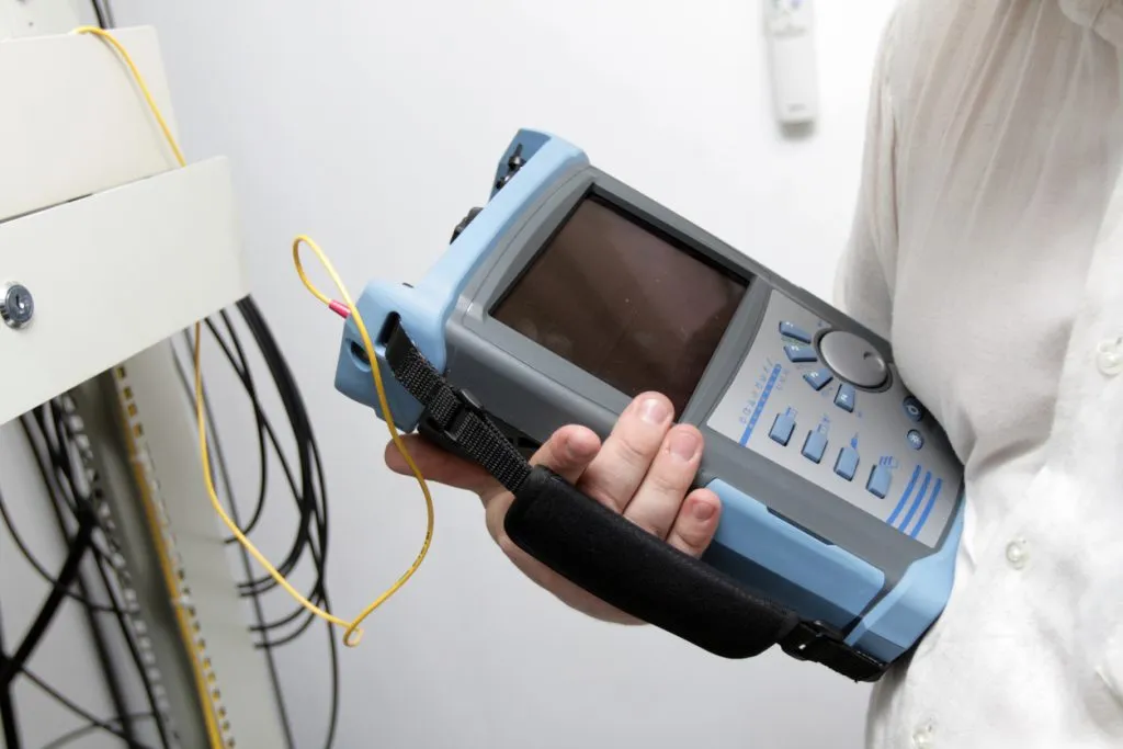 Technician using a network testing device for site survey or troubleshooting
