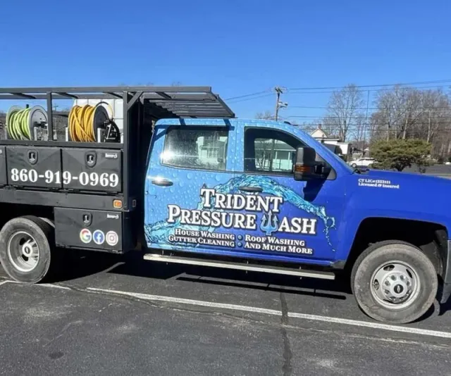 Blue service truck for Trident Pressure Wash with a water graphic, phone number 860-919-0969, and services listed including house washing, roof washing, gutter cleaning, and more.