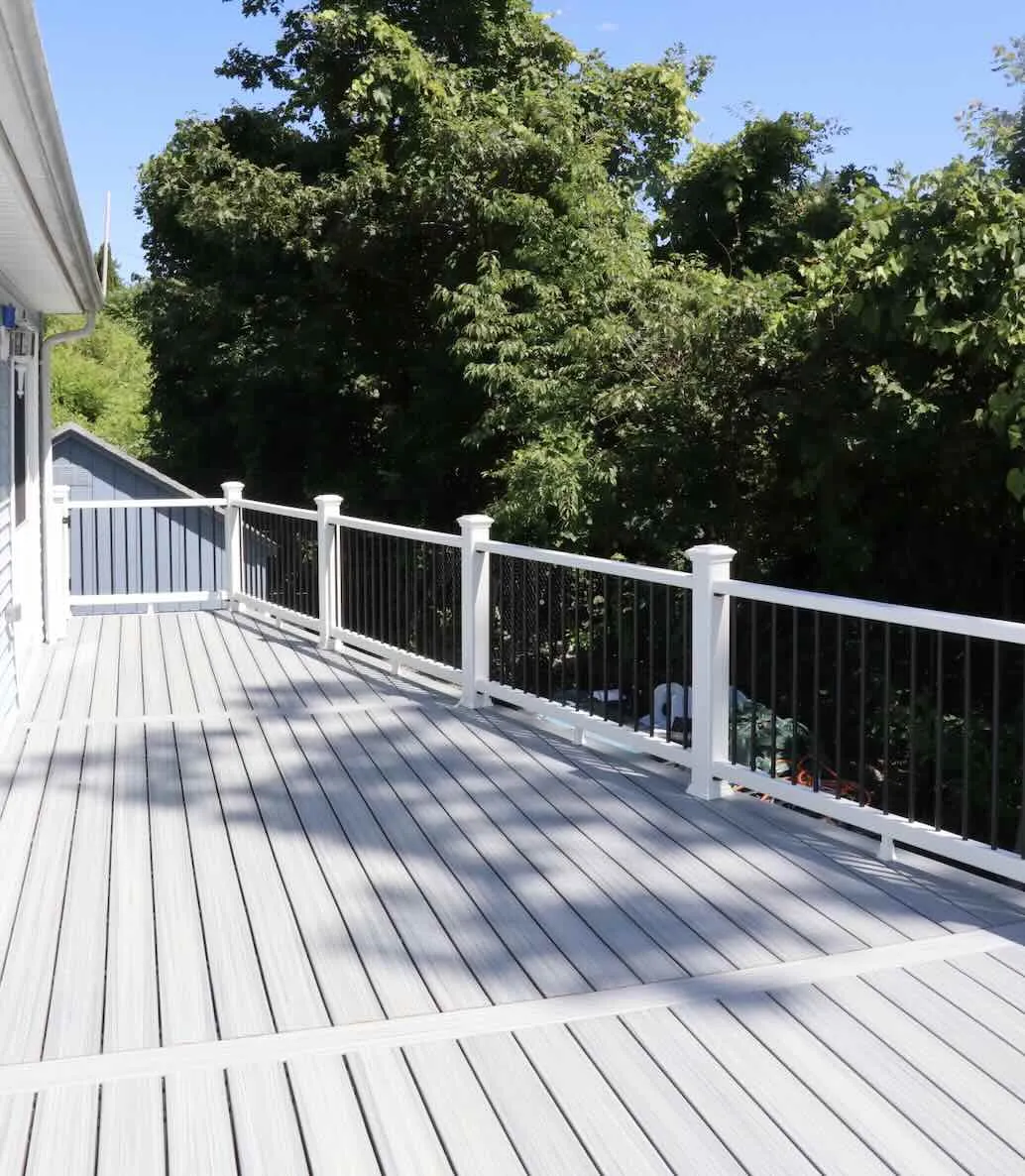 Pvc deck with black balusters railing featuring trees on the background in worcester ma