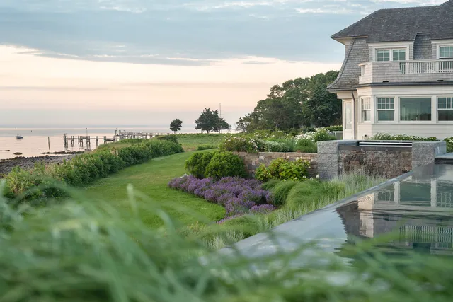 Lawn, lavender borders and stone walls above a tidal shoreline