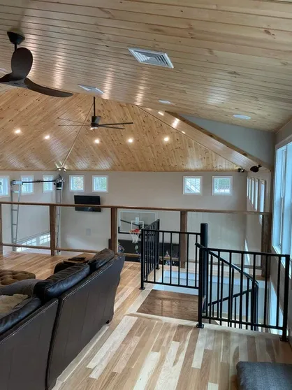 Open-concept living room with wood ceiling and loft railing