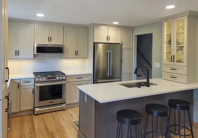 Designer’s Choice cabinetry – Perimeter painted Limestone; Island is stained Denali. Cabinet features: Lazy Susan, roll out shelves, double crown molding, wall hatch. 

Haute Designs Kitchen & Bath.