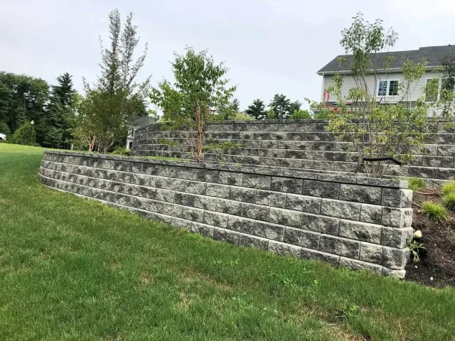 Terraced segmental retaining wall supporting a raised lawn