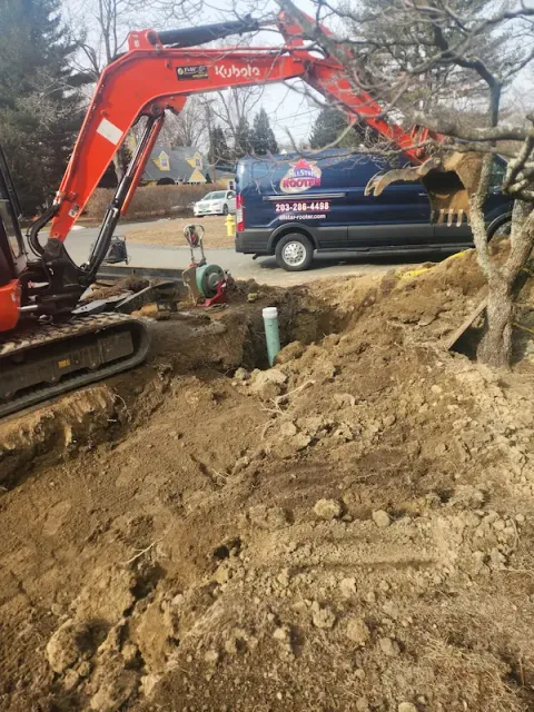 Excavator digging trench for emergency sewer line repair in Norwalk CT