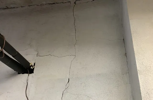 Close-up of a vertical wall crack in an interior plaster surface
