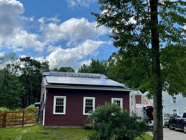 Black solar panels installed on a dark red New Hampshire home by Granite State Solar.