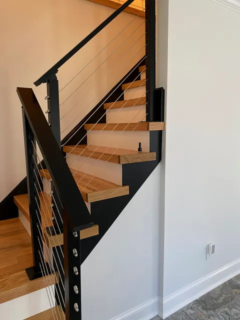 Oak staircase with cable railing by Adael Construction