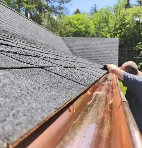 Close-up of copper seamless gutter and downspout on residential house in New Hampshire