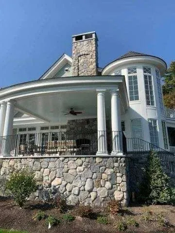 Stone house with white pillars and large windows