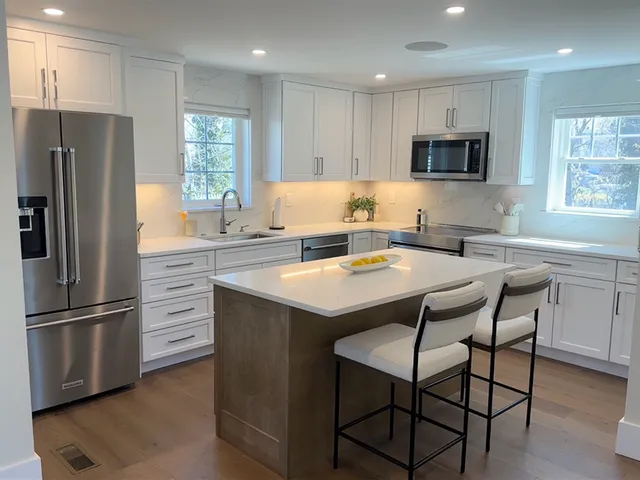 Modern open-plan kitchen with wood floors and an island with two seats in Boston