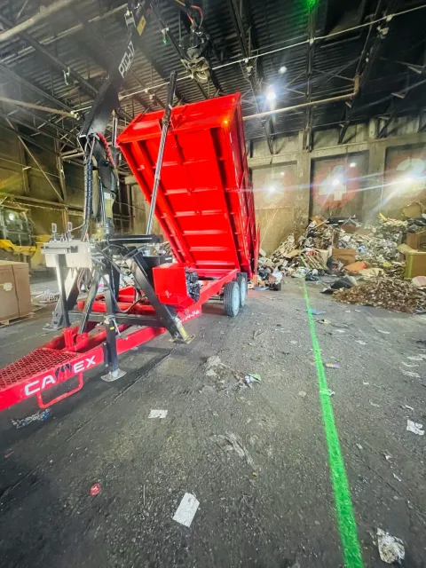Photo of a red truck dumping junk at a disposal center