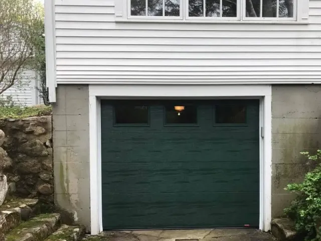 A white house with a green garage door