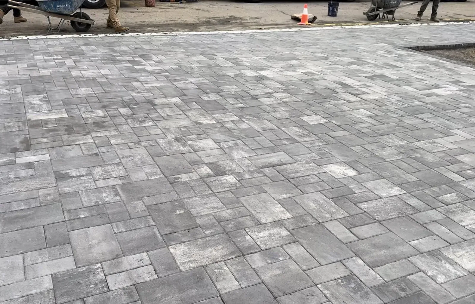 Completed gray paver patio with a precise running pattern