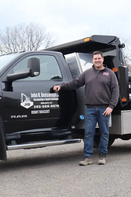 John H. Bensavage standing by his branded RAM work truck in Wolcott, CT