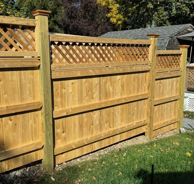 A wooden fence with a lattice on top of it