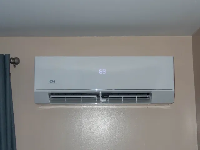 Wall-mounted air conditioner displaying the temperature 69 degrees.