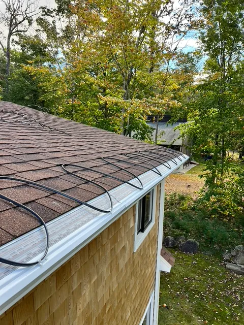 Heat cable installed in gutter channel and along roof shingles