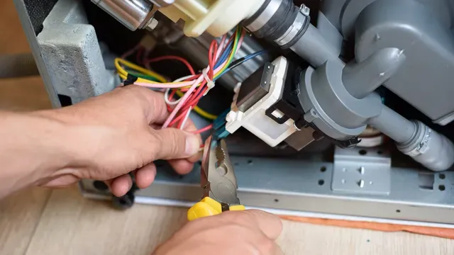 A person is fixing a dishwasher with a pair of pliers.