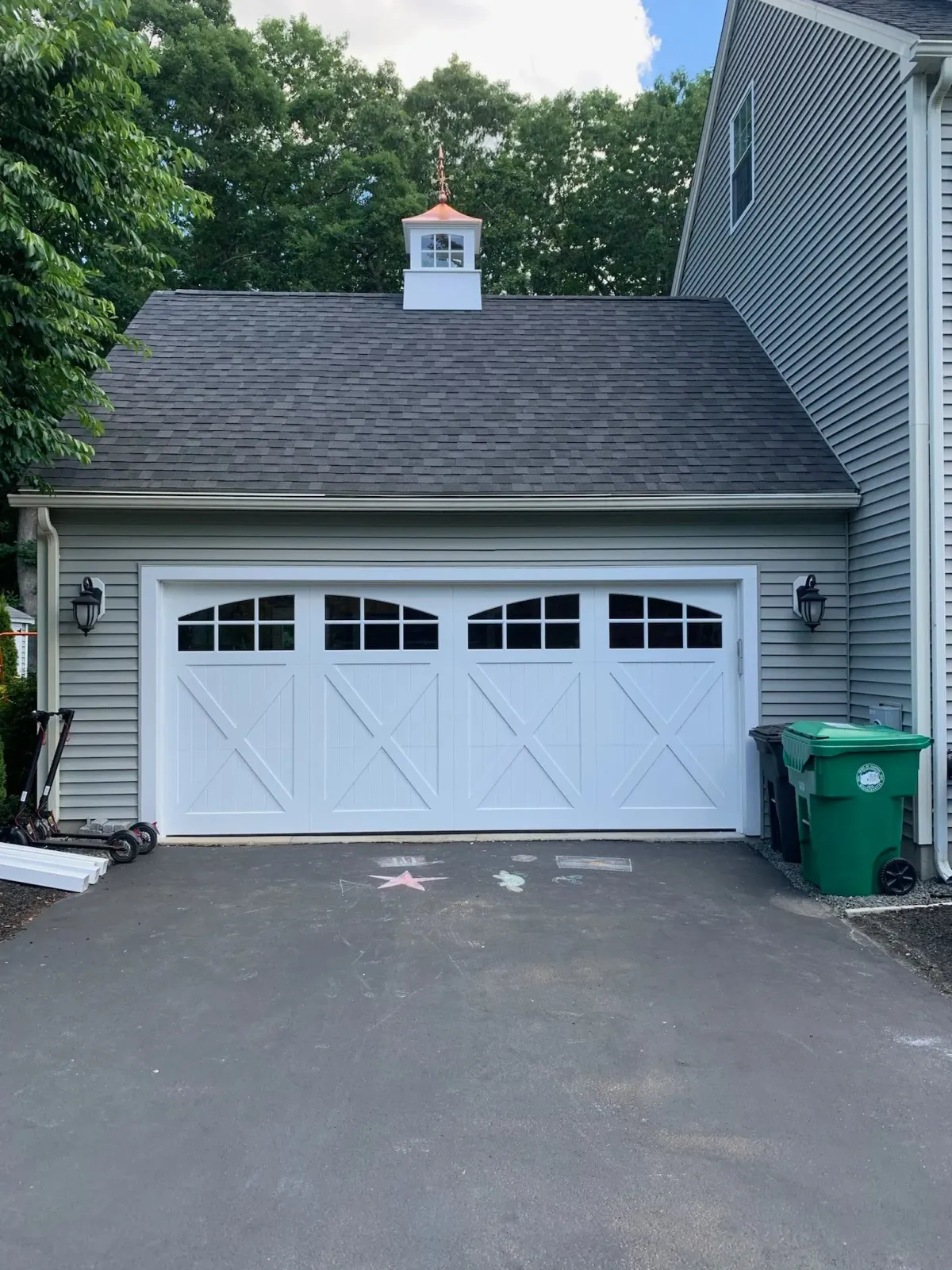 A white garage door is sitting in front of a house.