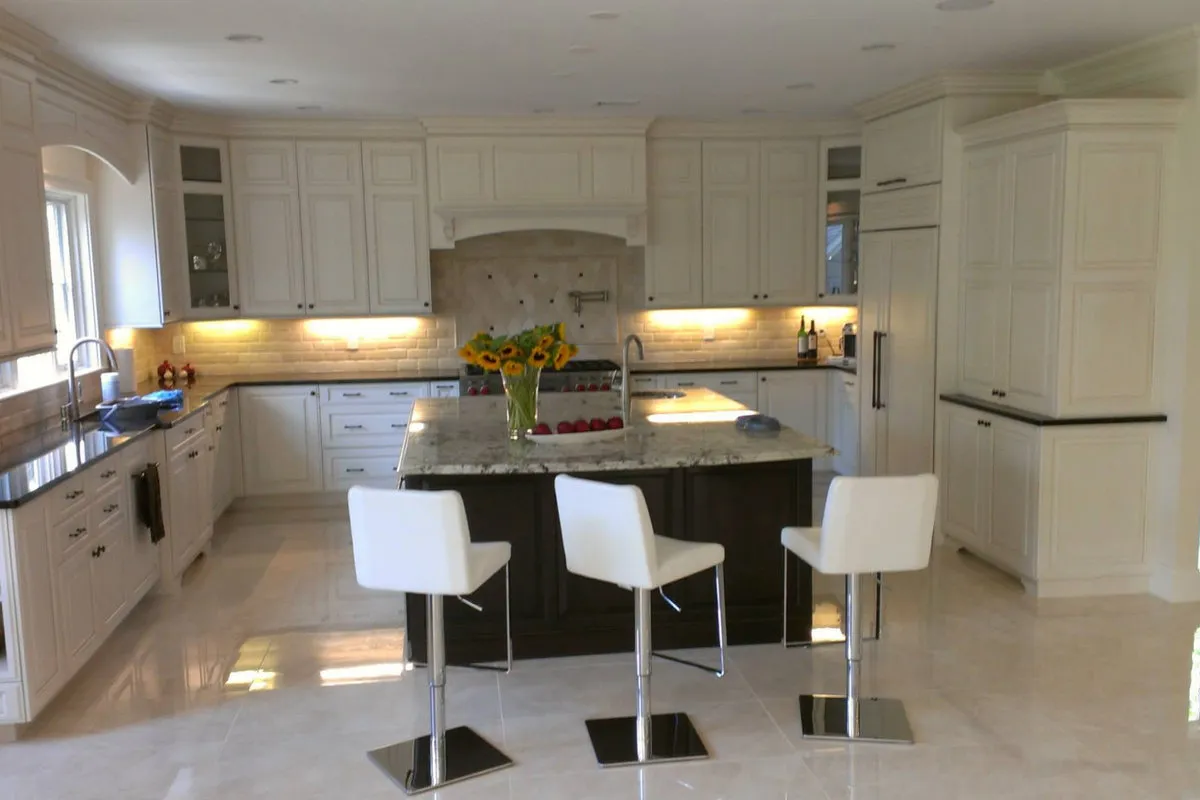 Hand Honed Marble — white kitchen with travertine floor, granite island, and marble backsplash. Boston.