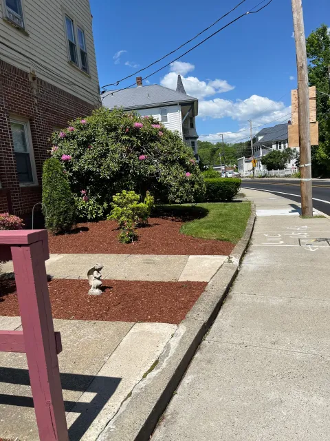 A statue of a rabbit is on the sidewalk next to a brick building