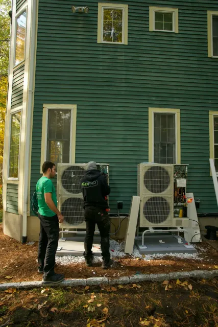 MJ Pro Energy technicians installing heat pumps at a Massachusetts home