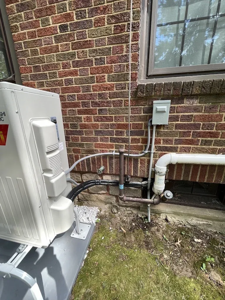 an exterior brick wall with an electrical service hook up