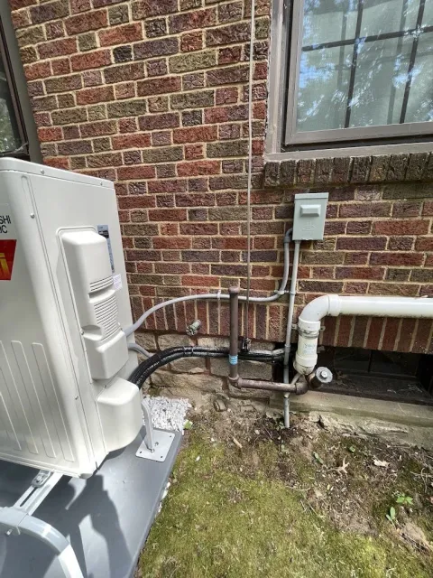 an exterior brick wall with an electrical service hook up