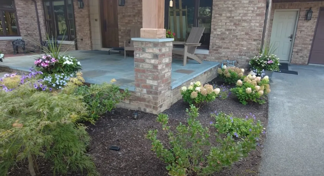 Custom hardscaping with bluestone patio and brick columns in Brookline, MA