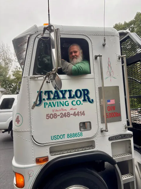A man is sitting in the driver 's seat of a truck.