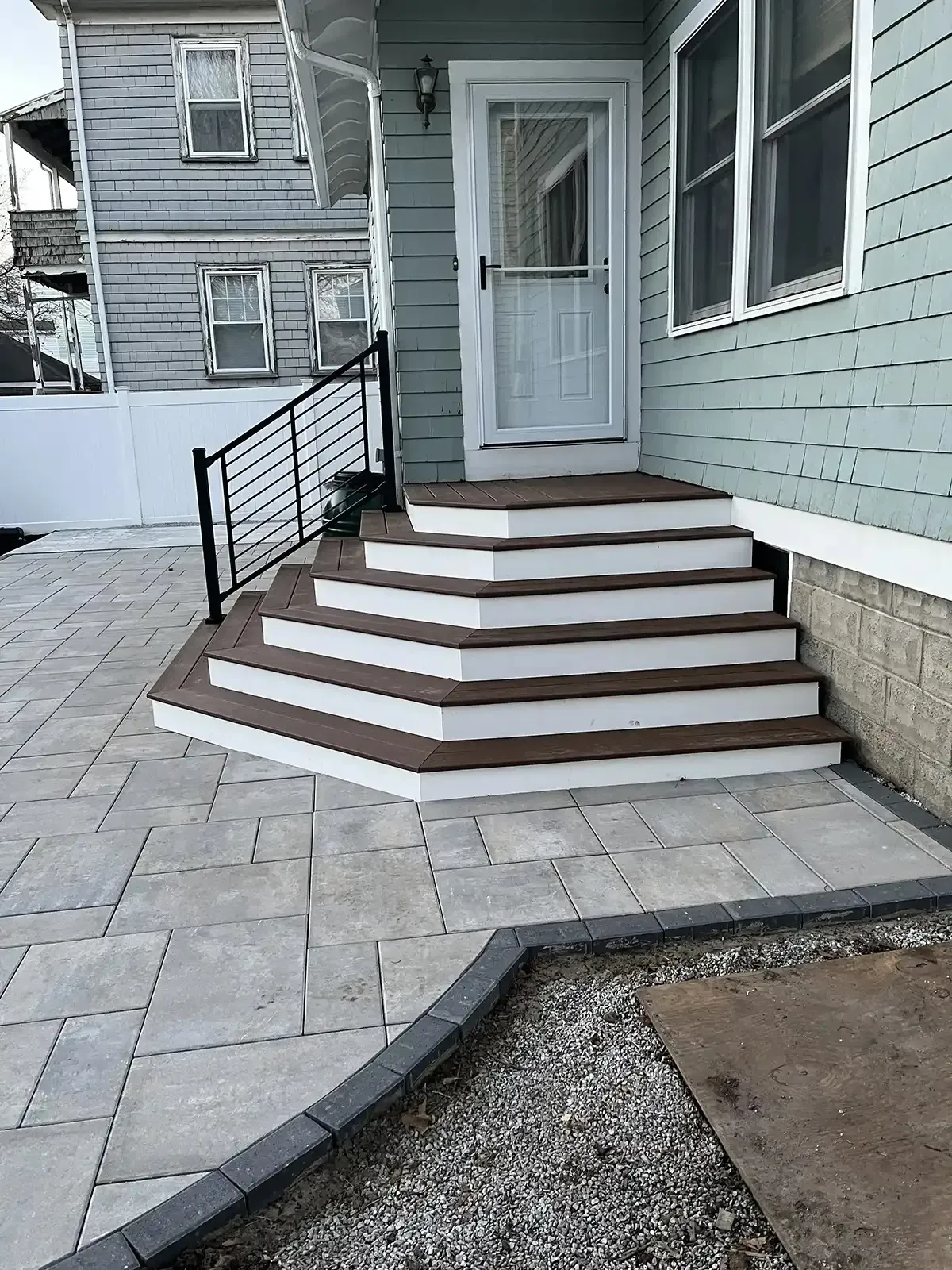 Composite entry steps with paver patio and steel railing