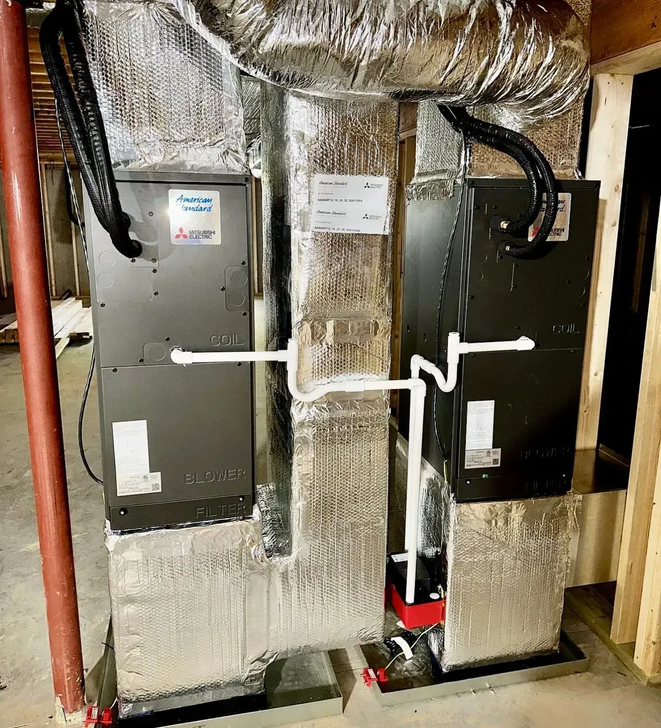 Insulated HVAC ducts and equipment in a utility closet with silver foil wrap and black pipes