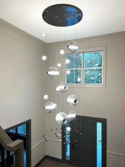 A beautiful modern chandelier above the stares in a modern tasteful home.