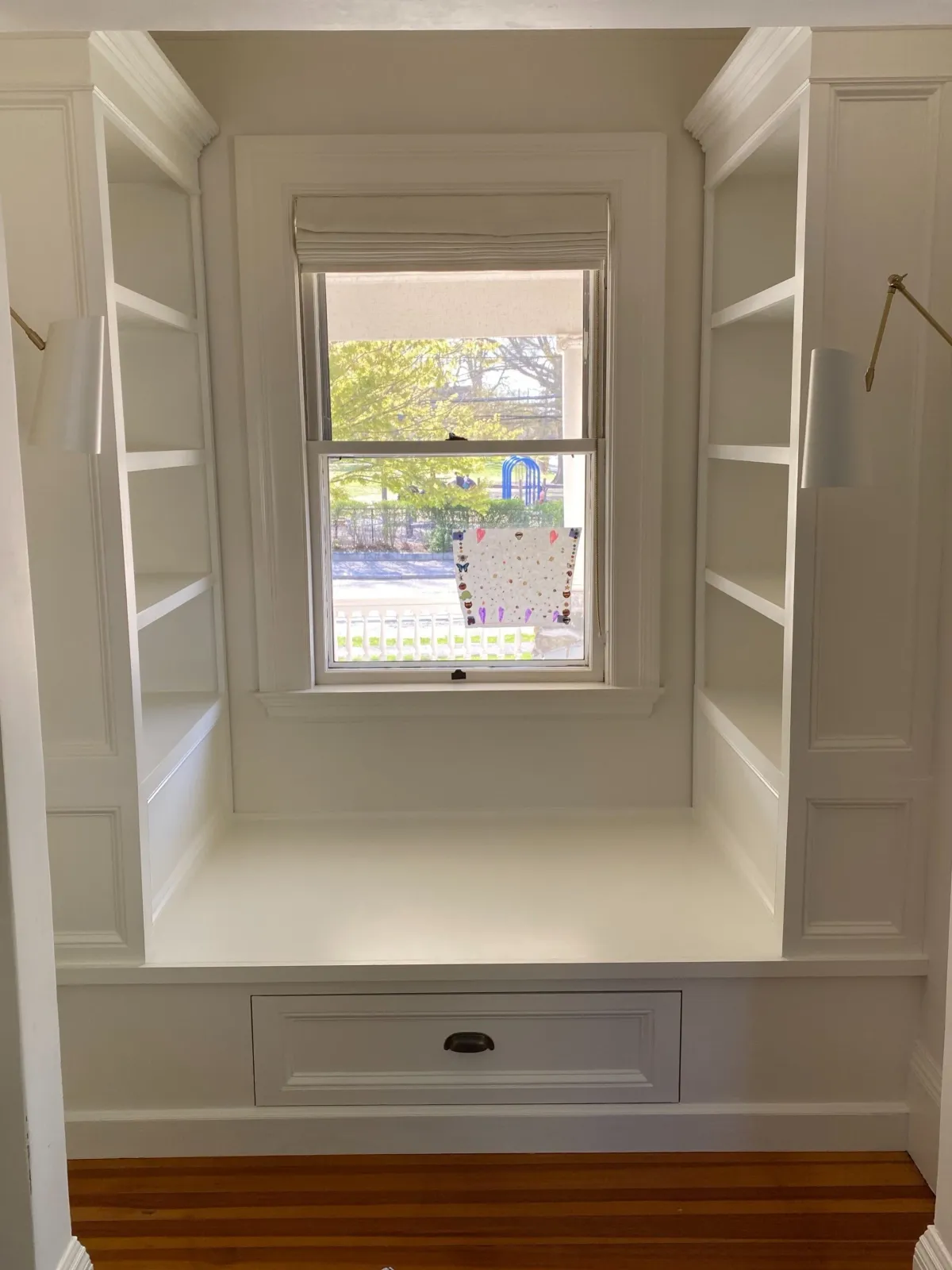 A massive window seat with matching shelving in a cozy alcove.