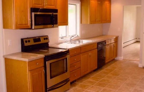 Completed kitchen — oak cabinetry, stainless range and tile floor