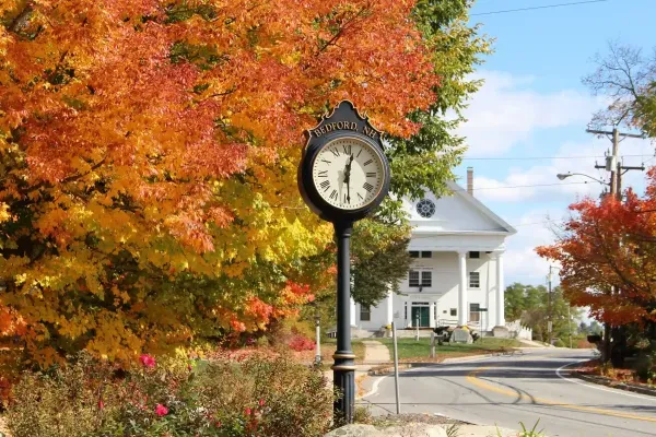 Historic town center clock and autumn trees in Bedford NH, local service area for Nault's Plumbing and Heating
