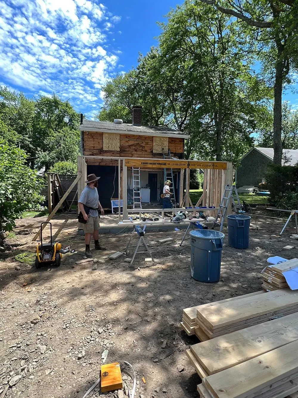 A man is standing in front of a house under construction.