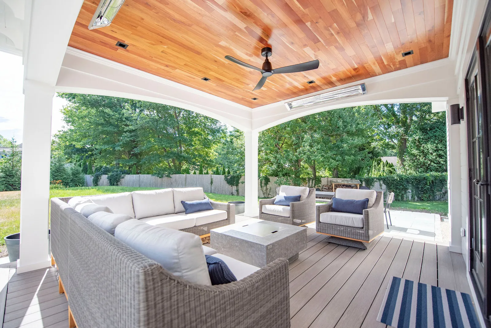 This custom home renovation features a covered outdoor deck with heating for the winter and fans for the summer. Compositie materials are used to make this outdoor living space durable and easy to clean.