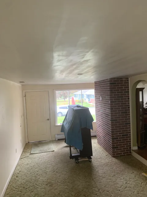 A living room with a piano and a brick wall.