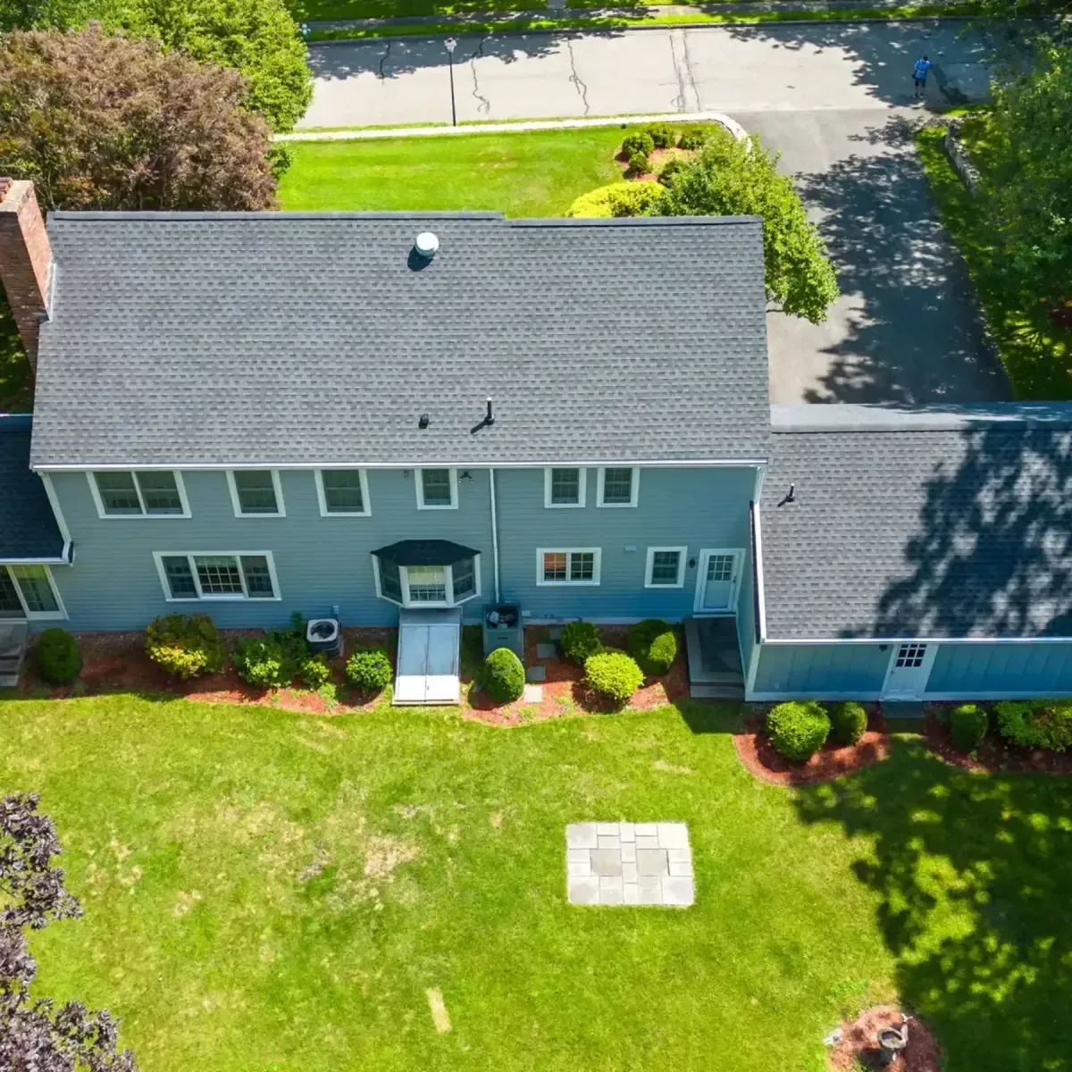Aerial view of a residential home in Methuen, MA with a new asphalt shingle roof, landscaped yard, and well-maintained exterior, showcasing Crown Roofing's quality craftsmanship and roofing services.