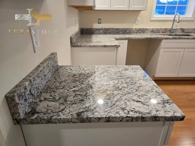 Kitchen with granite countertops and white cabinets.