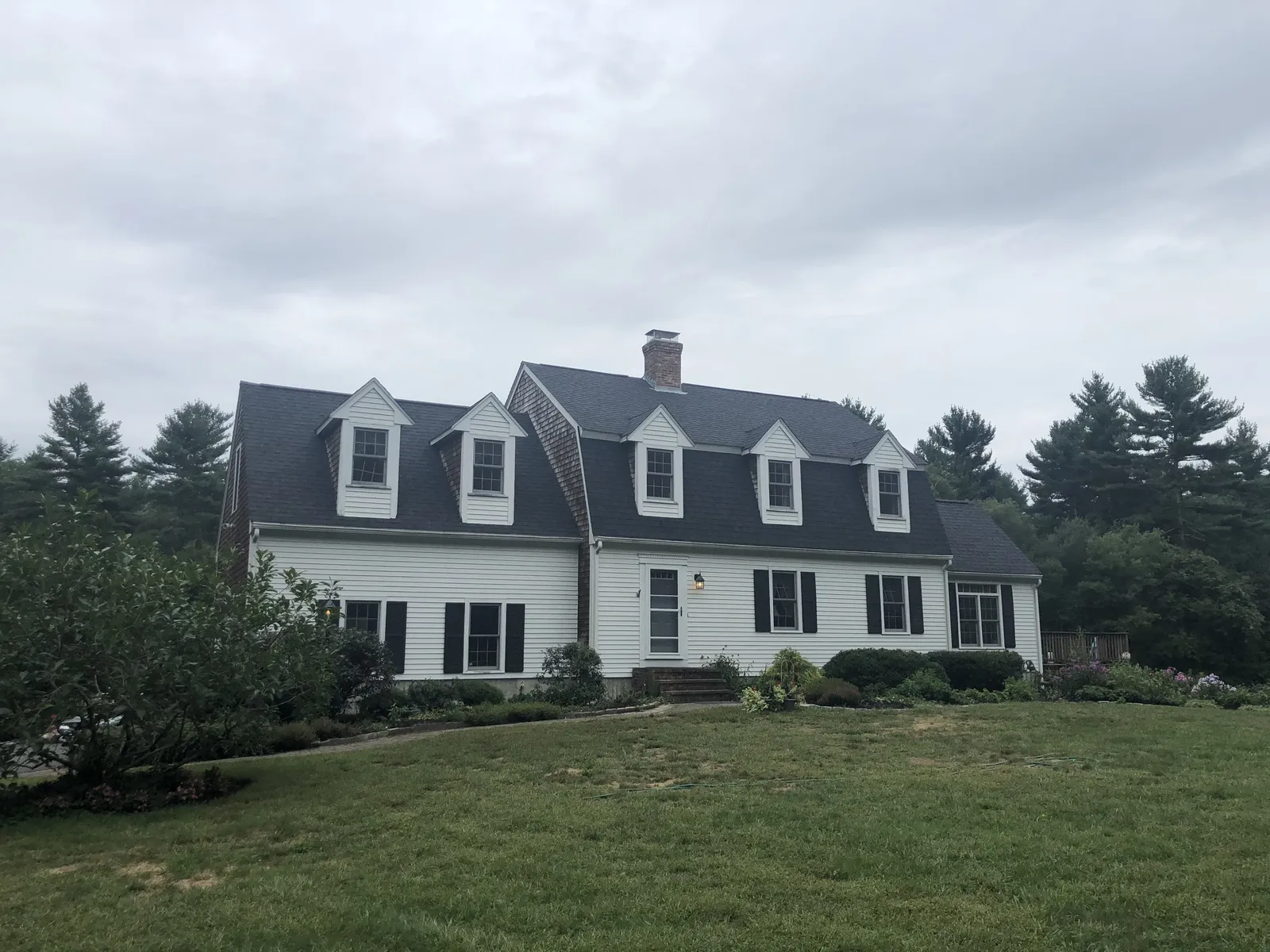 Colonial home exterior in Plympton, MA with a new shingle roof installed by Storm King Roofing