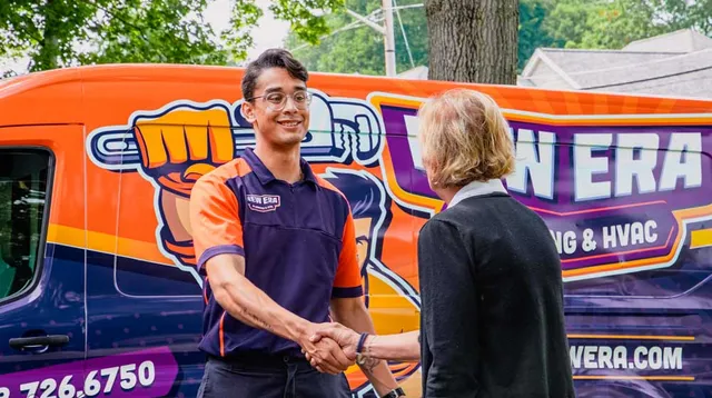 A New Era team member shakes hands with a client