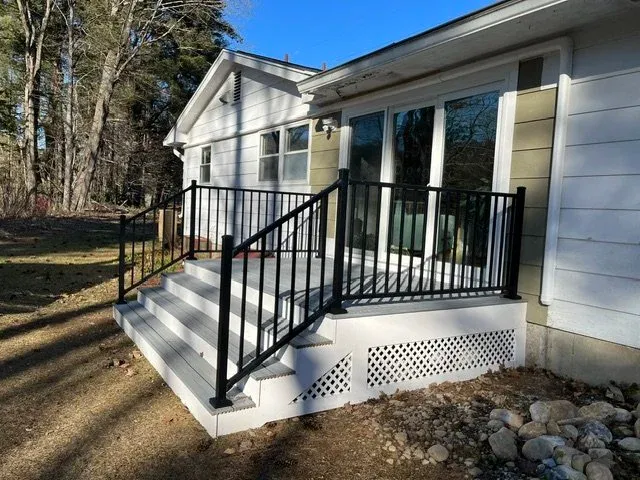 Rear deck built with Trex composite decking and metal railings during a whole house renovation.