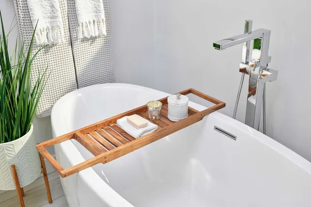 Freestanding soaking tub in a spa-like bathroom with natural light, greenery, and minimalist finishes designed for relaxation.